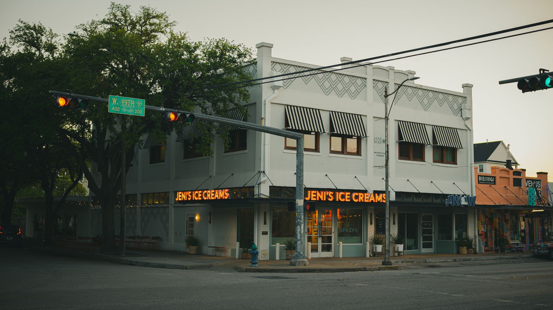 Tree-lined street in Montrose Houston with sidewalk cafes and local shops