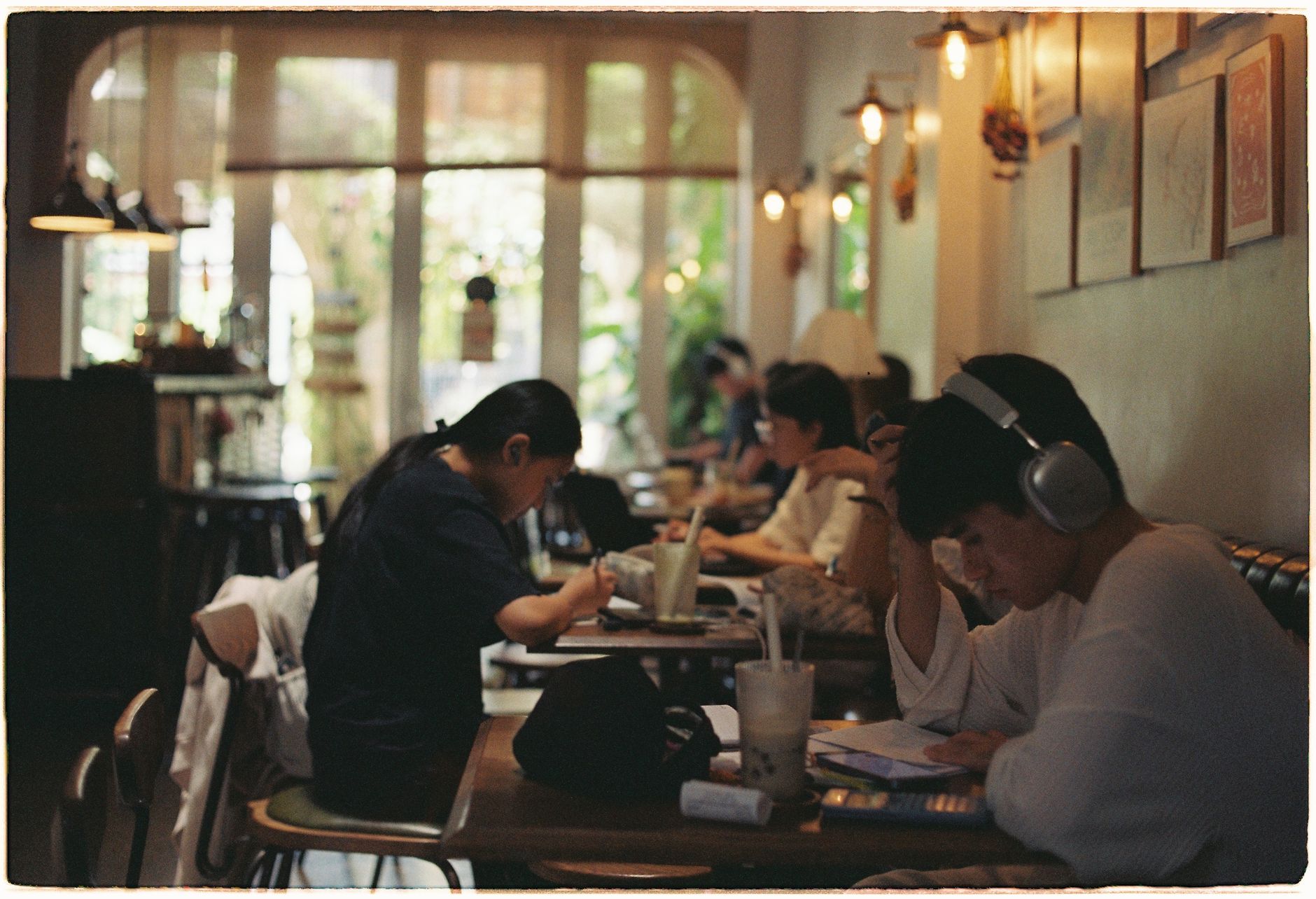 leaseradius-1791724455851 A group of people studying and working in a cozy, well-lit cafe setting.