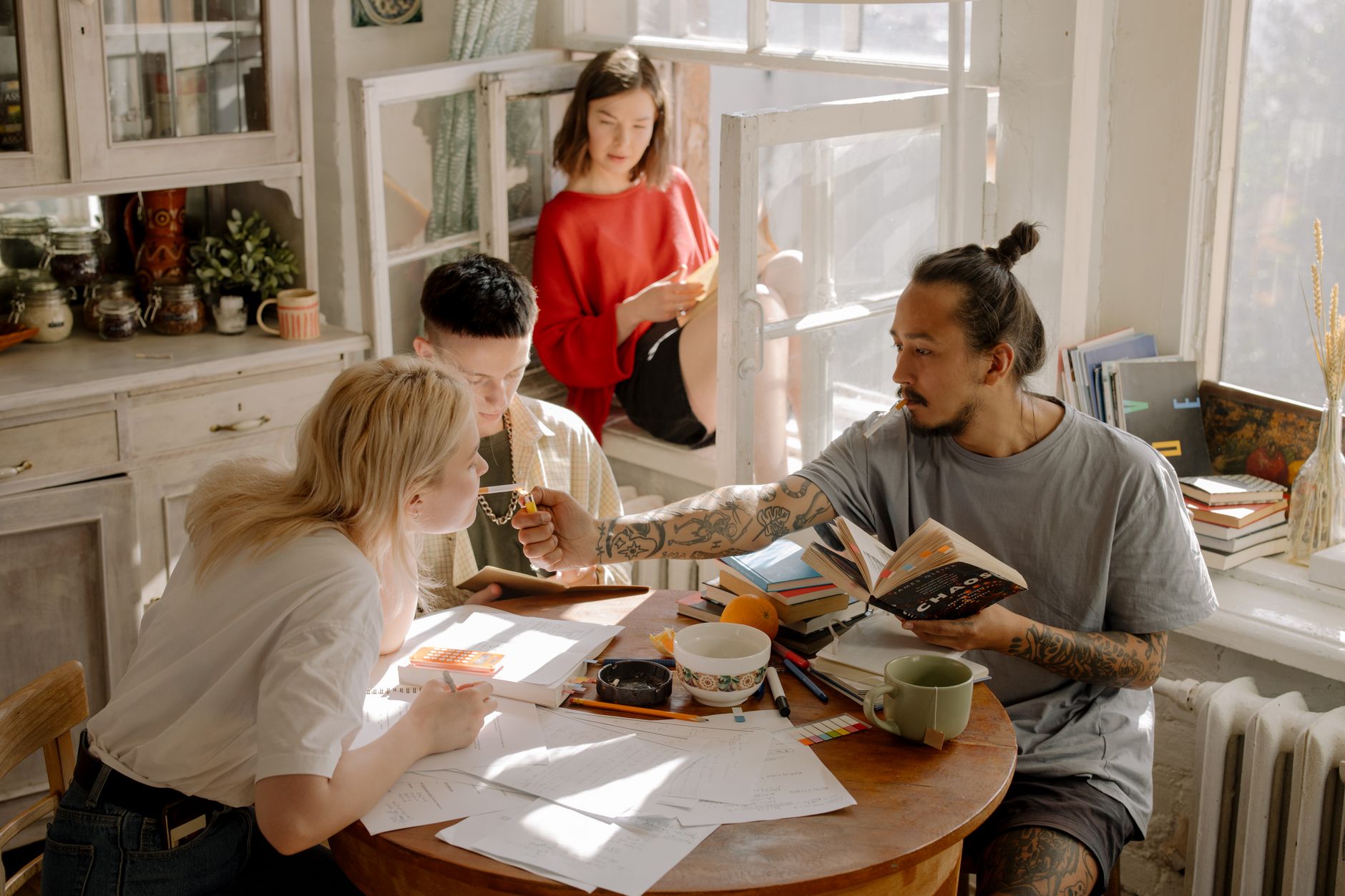 leaseradius-1792002541061 Group of people studying and relaxing in a bright, cozy apartment with natural light.