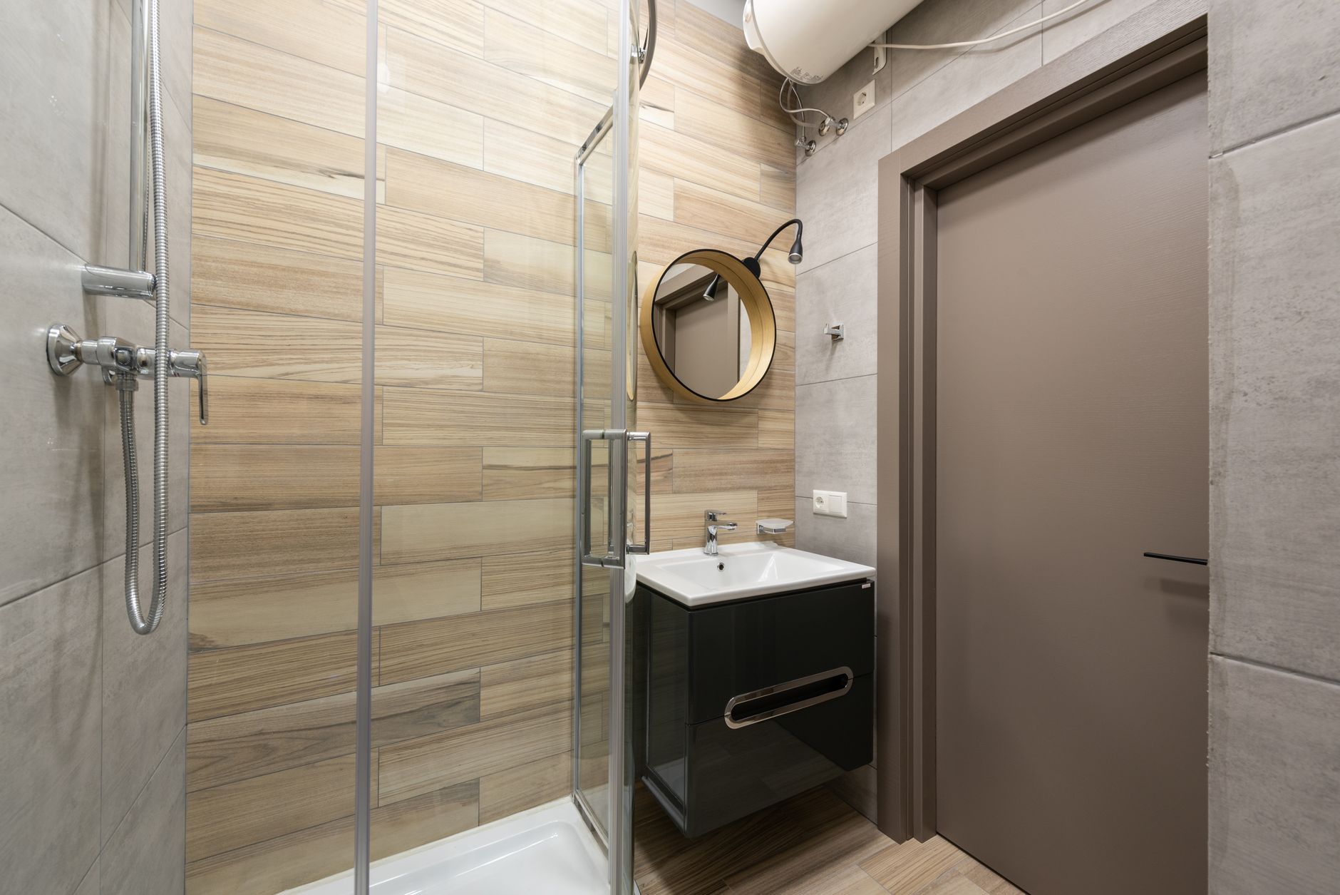 leaseradius-1792329592701 Interior of modern bathroom with ceramic sink and shower with glass walls designed in minimal style
